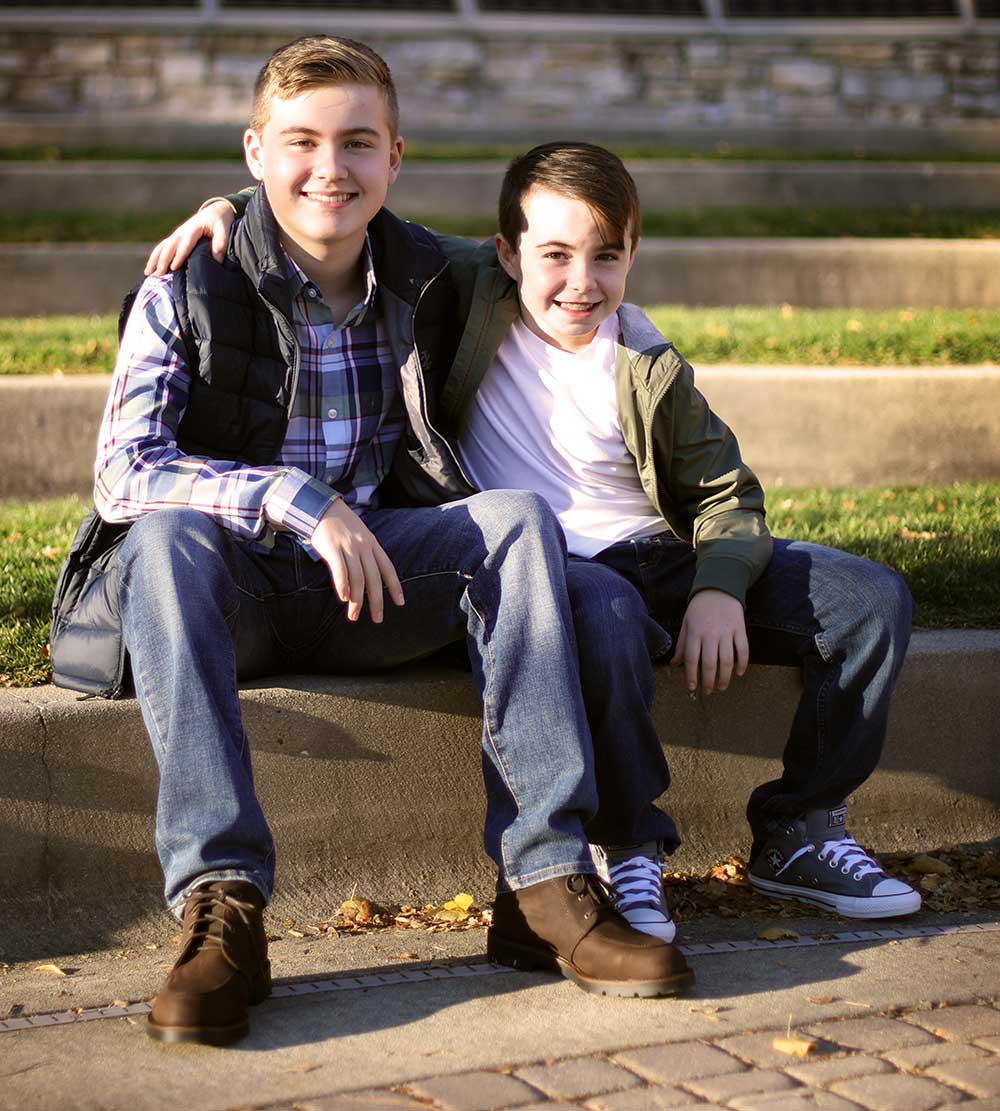 two young boys sitting and smiling together